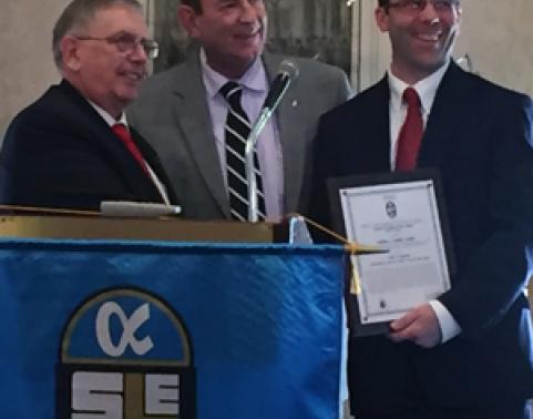 LMP's Bill Parker-Combes, Assistant Product Manager for Development and Deployment, accepts his award as the Logistician of the Year from GWAC-SOLE during an awards luncheon on 26 October 2016.