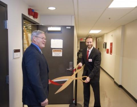 Mr. Burke cuts ribbon on door